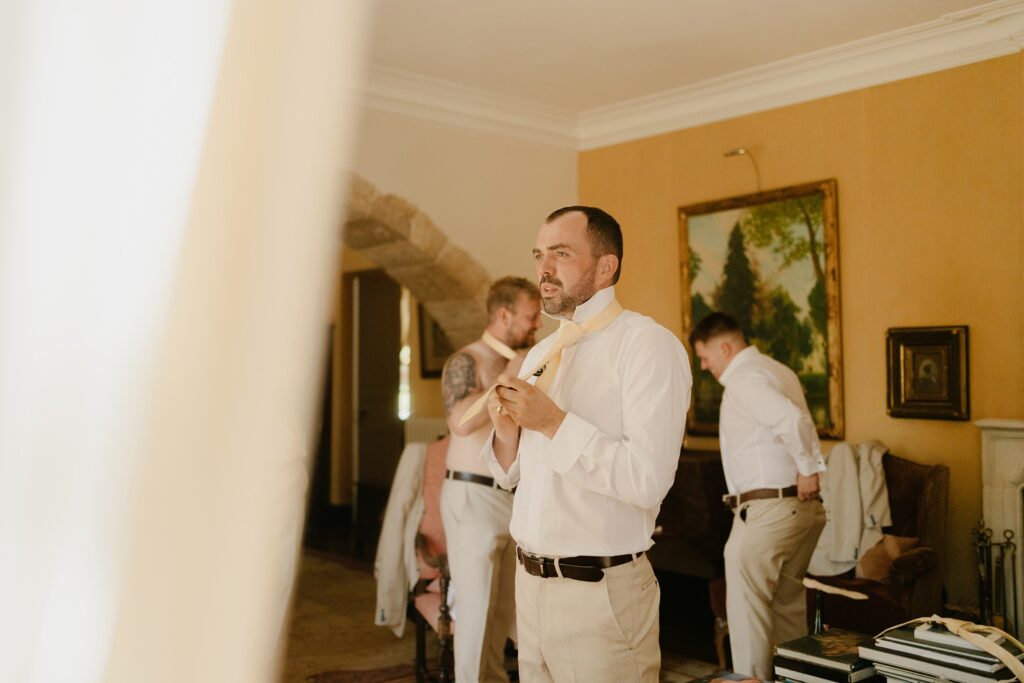 Groom in a room at Chateau de Malliac - photo by Jade Sequeval wedding Photographer in South West France
