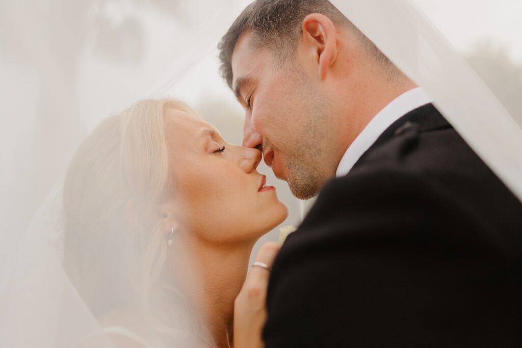 Bride and groom kissing under the veil at Chateau Réal - photo by Jade Sequeval wedding Photographer in Bordeaux