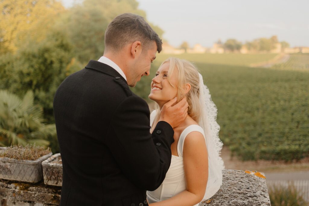 Bride and groom smiling at each other on the Bridal suite at Chateau Réal by Jade Sequeval wedding Photographer in Bordeaux